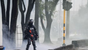 A riot police officer walks through a cloud of tear gas amid clashes with demonstrators during a protest against the government of Colombian President Ivan Duque in Bogota on June 9, (Photo by Juan BARRETO / AFP) (Photo by JUAN BARRETO/AFP via Getty Images)