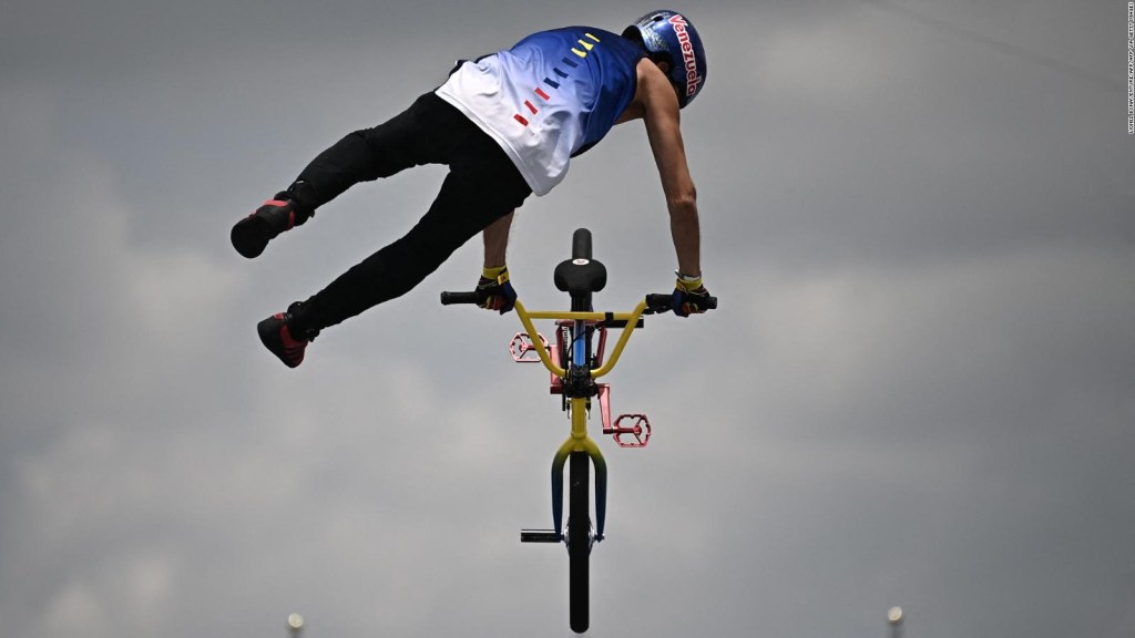 Daniel Dhers flies by bicycle and gives a medal to Venezuela