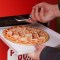 Máquina dispensadora entrega pizzas en Roma