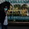 A woman wearing a face mask walks near a poster with images of Cuban revolutionary (L-R) Cuban national hero Jose Marti, Cuban late leader Fidel Castro, the Former First Secretary of the Communist Party Raul Castro and Cuban President Miguel Diaz-Canel, in Havana, on June 3 2021. - Out of the official scene for a month and a half, Cuban leader Raul Castro turns 90 on Thursday, after leaving the leadership of the ruling Communist Party on April 19, his last post. However, his image continues to be a daily sight in the streets of Havana and the official government recalled the date through all its channels. (Photo by YAMIL LAGE / AFP) (Photo by YAMIL LAGE/AFP via Getty Images)