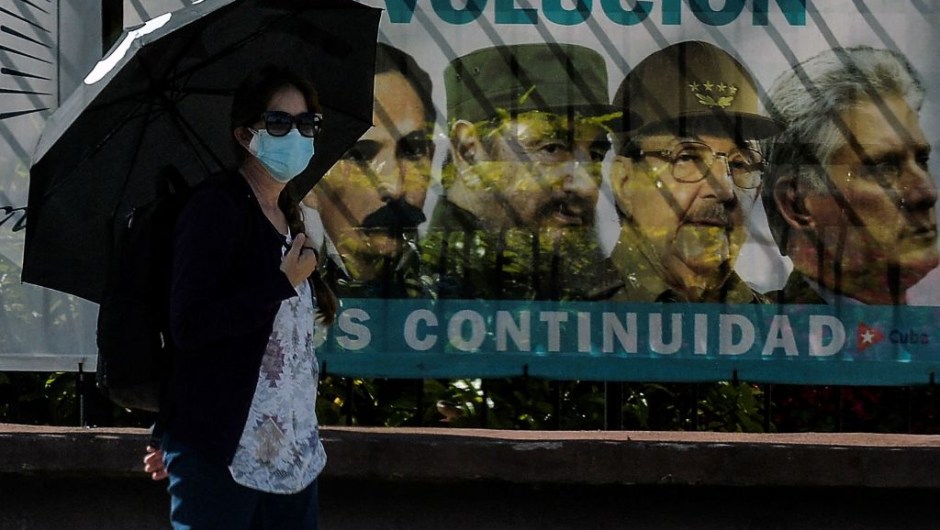 A woman wearing a face mask walks near a poster with images of Cuban revolutionary (LR) Cuban national hero Jose Marti, Cuban late leader Fidel Castro, the Former First Secretary of the Communist Party Raul Castro and Cuban President Miguel Diaz-Canel, in Havana , on June 3 2021. - Out of the official scene for a month and a half, Cuban leader Raul Castro turns 90 on Thursday, after leaving the leadership of the ruling Communist Party on April 19, his last post.  However, his image continues to be a daily sight in the streets of Havana and the official government recalled the date through all its channels.  (Photo by YAMIL LAGE / AFP) (Photo by YAMIL LAGE / AFP via Getty Images)