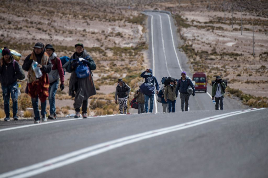 TOPSHOT - Venezuelan migrants walk towards Iquique from Colchane, Chile, after crossing from bordering Bolivia, on September 23, 2021. (Photo by MARTIN BERNETTI / AFP) (Photo by MARTIN BERNETTI/AFP via Getty Images)