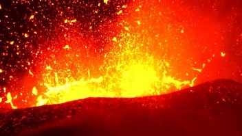 Mira la lava del volcán estallar como pintura anaranjada