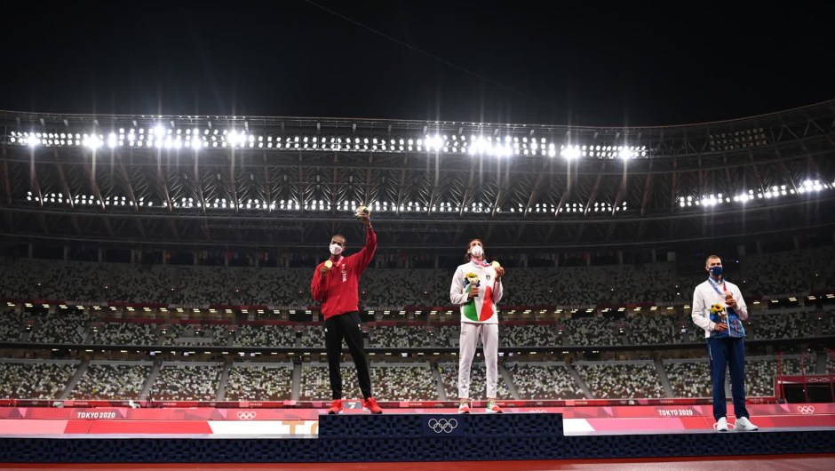 2 de agosto: el catarí Mutaz Essa Barshim, a la izquierda, y el italiano Gianmarco Tamberi comparten el podio durante una ceremonia de entrega de medallas olímpicas. Acordaron compartir la medalla de oro en salto de altura después de que ambos superaran los 2,37 metros, pero no lograran superar los 2,39. Maksim Nedasekau, de Bielorrusia, recibió el bronce. No se concedió ninguna medalla de plata. (Crédito: Dylan Martínez/Reuters)