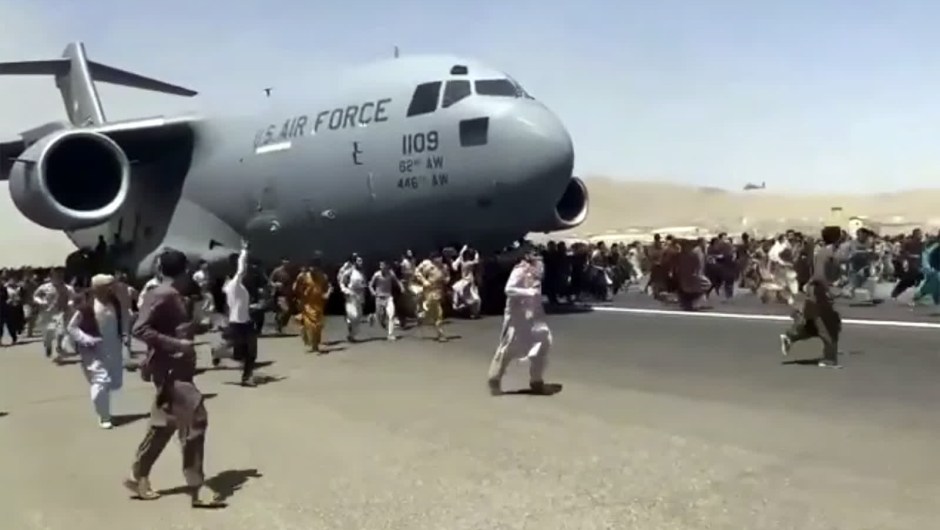 16 de agosto: afganos corren junto a un avión de transporte de la Fuerza Aérea estadounidense en la pista del aeropuerto internacional de Kabul. Un video muestra a personas que se aferran al fuselaje del avión mientras se desplaza. Al día siguiente de la toma del poder por parte de los talibanes, cientos de personas se agolparon en la pista, buscando desesperadamente una ruta para salir del país. (Crédito: AP)