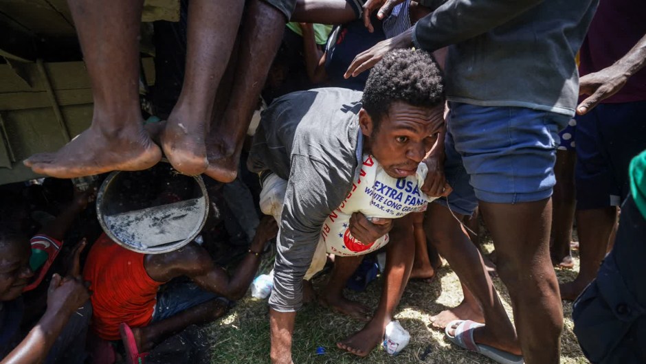 20 de agosto: un hombre se arrastra con una bolsa de arroz donada después de que la gente en Vye Terre, Haití, adelantara temporalmente un camión cargado de suministros de ayuda. Haití fue devastada seis días antes por un terremoto de magnitud 7,2. (Crédito: Fernando Llano/AP)