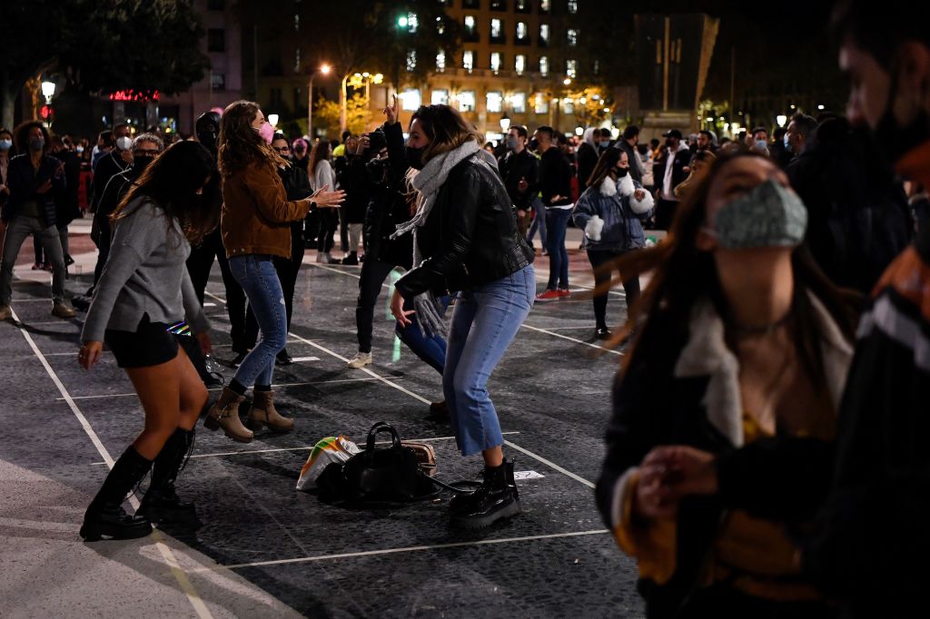 People wearing face masks dance during a protest called by nightclub guilds in support of the reopening of nightlife spots in Barcelona on November 21, 2020. - Bars, restaurants and movie theatres will reopen next week in Catalonia, after being closed for over a month as part of measures to slow coronavirus infections, the regional government said, maintaining some restrictions including a night-time curfew as well as the limits on movements of people into and out of the region. (Photo by Pau BARRENA / AFP) (Photo by PAU BARRENA/AFP via Getty Images)