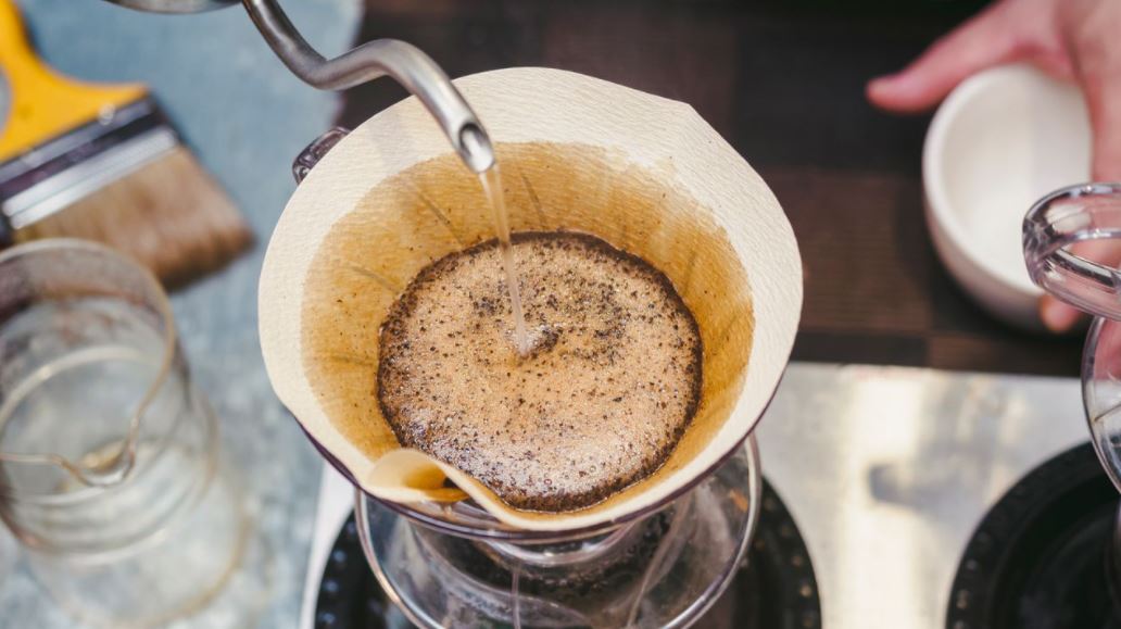Vierta el filtro con el café molido en el embudo enfocado preparación del  café con filtro de goteo vierta el método alternativo de verter agua sobre  los granos de café tostados y