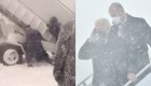 En plena tormenta de nieve, Biden es asistido por militares para bajar del Air Force One en la pista de aterrizaje 