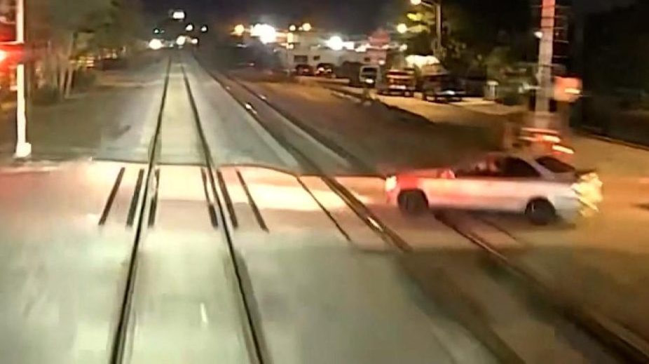 Train hits a car and splits it in half.  The driver survives