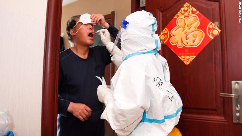 Seorang petugas kesehatan melakukan pemeriksaan dari pintu ke pintu di Changchun pada 5 April.
