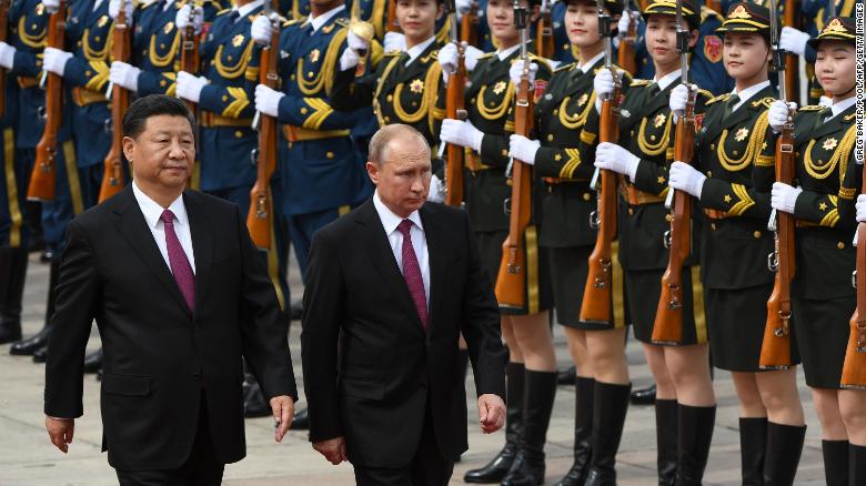 Chinese President Xi Jinping and Russian President Vladimir Putin review the military honor guard outside the Great Hall of the People in Beijing on June 8, 2018.