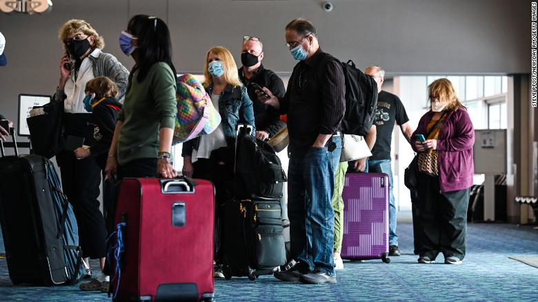 Passengers wearing face masks line up in March 2021 at a ticket counter in the main terminal at Long Island MacArthur Airport in Ronkonkoma, New York.