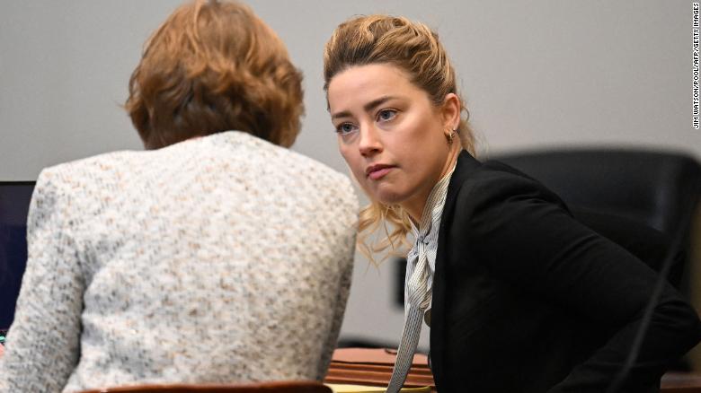 Amber Heard habla con uno de sus abogados en el Tribunal de Circuito del Condado de Fairfax el 19 de abril.