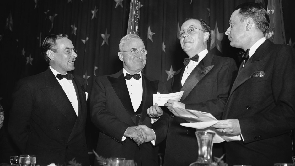 El presidente Harry Truman, segundo por la izquierda, entrega un cheque de US$ 500 a Peter Edson, segundo por la derecha, por haber ganado el premio Raymond Clapper Memorial en 1949.AP