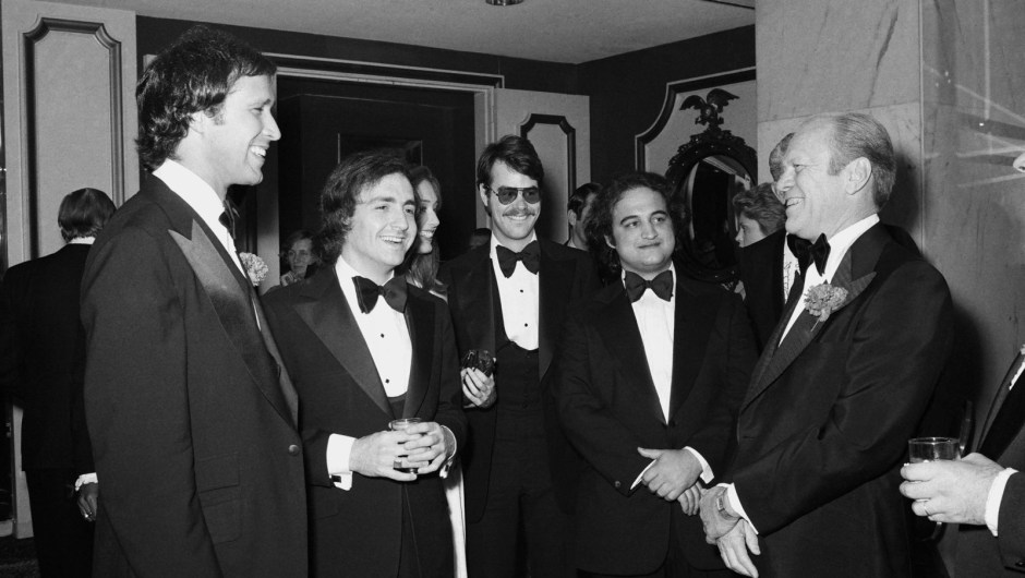 El presidente Gerald Ford, a la derecha, habla con el cómico Chevy Chase, a la izquierda, en 1976. Chase hizo un famoso retrato de Ford como torpe en "Saturday Night Live". Entre ambos, de izquierda a derecha, el creador de "Saturday Night Live", Lorne Michaels, y los miembros del reparto Dan Aykroyd y John Belushi.Fred Hermansky/NBCUniversal/Getty Images