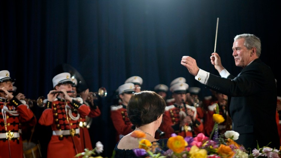 El presidente George W. Bush dirige la Banda del Cuerpo de Marines durante la cena en 2008.Kristoffer Tripplaar/Pool/Getty Images