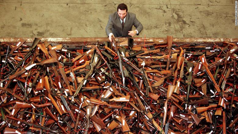 Un encargado del proyecto de reforma de las armas para la policía de Nueva Gales del Sur observa una pila de miles de armas de fuego en Sydney que habían sido entregadas como parte del plan de recompra del gobierno australiano en julio de 1996.