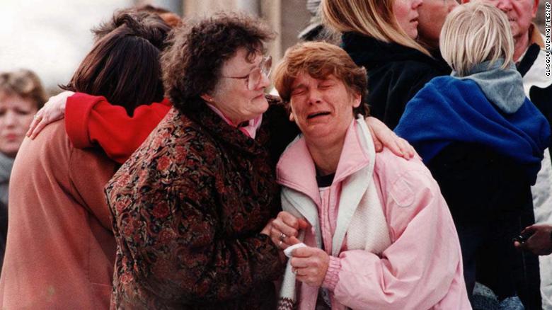Un grupo de familiares cerca de la escuela primaria de Dunblane, Escocia, donde un atacante mató a 16 niños y un profesor en 1996.