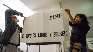 Two people set up a voting booth during a national referendum in Mexico City, on August 1, 2021. - Mexicans voted Sunday in a national referendum promoted by President Andres Manuel Lopez Obrador on whether to investigate and prosecute his predecessors for alleged corruption. (Photo by CLAUDIO CRUZ / AFP) (Photo by CLAUDIO CRUZ/AFP via Getty Images)