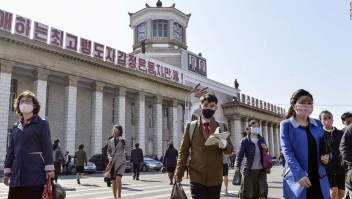 Personas con mascarillas caminan en medio de la preocupación por el covid-19 frente a la Estación Pyongyang, en Pyongyang, Corea del Norte, el 27 de abril de 2020.