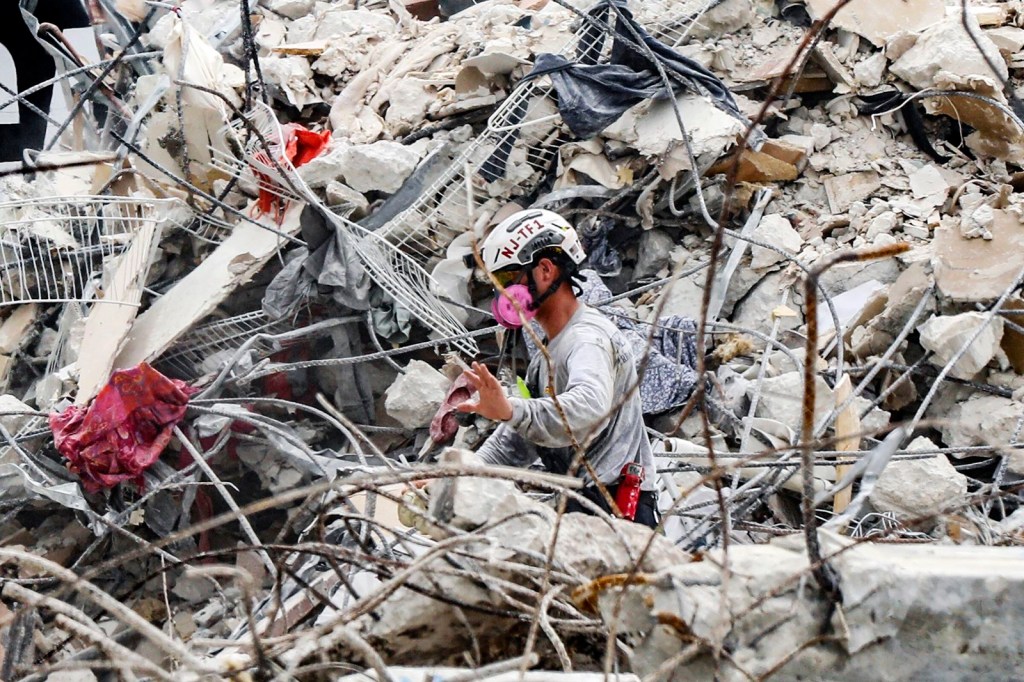 Un miembro de un equipo de búsqueda mueve los escombros en el lugar el 7 de julio. Las autoridades pasaron de la búsqueda y el rescate a la búsqueda y la recuperación después de determinar que "la viabilidad de la vida en los escombros" era baja, según dijo el jefe de bomberos del condado de Miami-Dade, Alan Cominsky. (Foto: Al Diaz/AP)