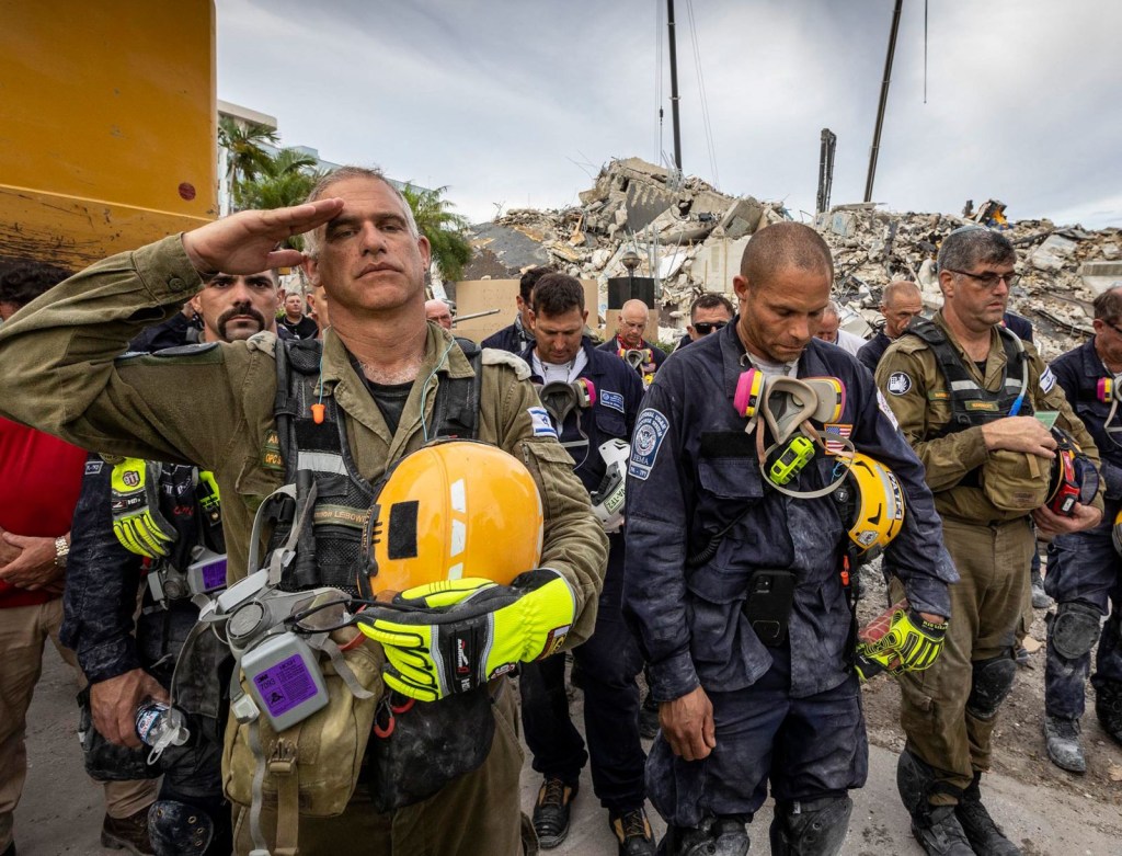 Trabajadores se reúnen para un momento de silencio y oración después de que se anunciara que los esfuerzos de rescate pasarían a ser una operación de recuperación. (Foto: Jose A Iglesias/Pool/Getty Images)