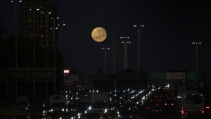 La luna llena se pone en la avenida General Paz de Buenos Aires, el 13 de julio de 2022
