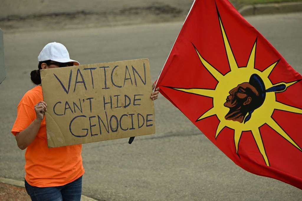 Un manifestante sostiene un cartel que dice "El Vaticano no puede ocultar el genocidio" durante la llegada del papa Francisco a Canadá el 24 de julio. (Crédito: Patrick T. Fallon/ AFP/ Getty Images)