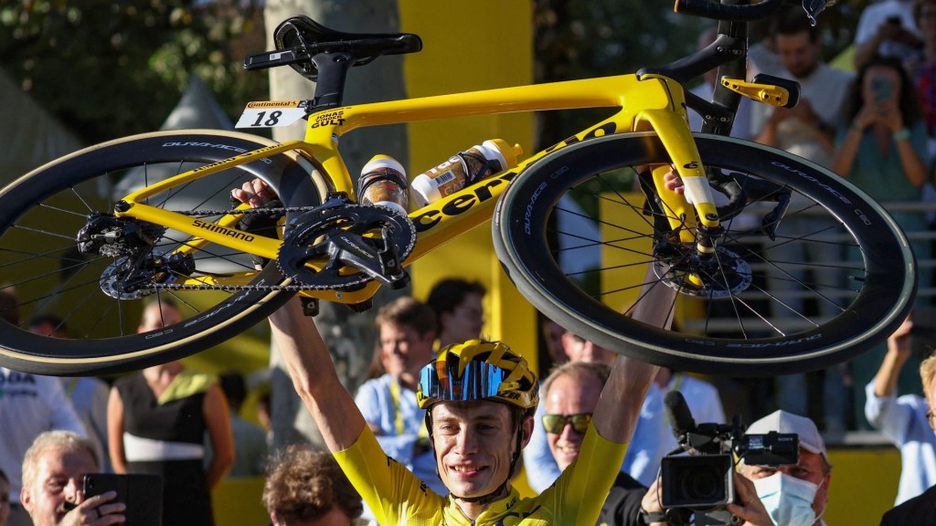 El ciclista danés del equipo Jumbo-Visma, Jonas Vingegaard, con el maillot amarillo de líder de la general, levanta su bicicleta mientras celebra su victoria en la 109ª edición del Tour de Francia.