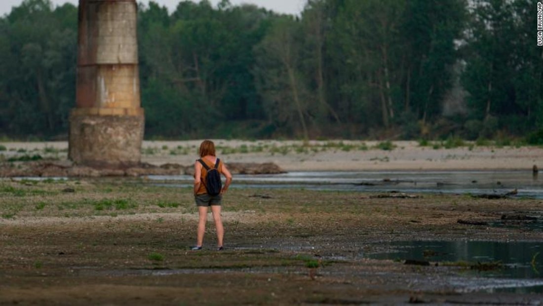 Una mujer se encuentra en el lecho del río Po junto al puente de la Becca en Linarolo, cerca de Pavía, Italia, el 27 de junio de 2022.