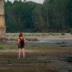 Una mujer se encuentra en el lecho del río Po junto al puente de la Becca en Linarolo, cerca de Pavía, Italia, el 27 de junio de 2022.