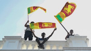 Manifestantes ondean banderas de Sri Lanka desde un balcón dentro del edificio de la oficina del primer ministro de Sri Lanka durante una protesta antigubernamental, en Colombo, el 13 de julio de 2022. (Foto: ARUN SANKAR/AFP vía Getty Images)