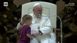 Niño se acerca al papa durante audiencia en el Vaticano