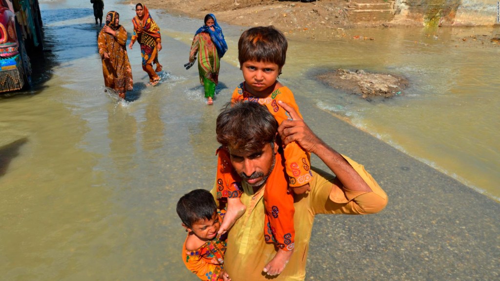 Un hombre desplazado saca a sus hijas de su casa afectada por las inundaciones en Jaffarabad, un distrito de la provincia suroccidental paquistaní de Baluchistán, el sábado.