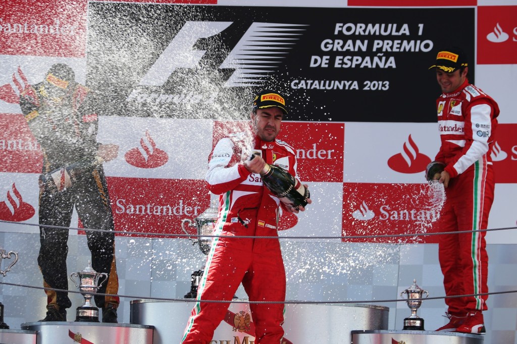 Race winner Spaniard Fernando Alonso (centre) of Ferrari celebrates his victory on the podium at the Spanish Grand Prix on May 12, 2013. Second place went to Finn Kimi Raikkonen (left ), from Lotus;  and the third position, for the Brazilian Felipe Massa, from Ferrari.