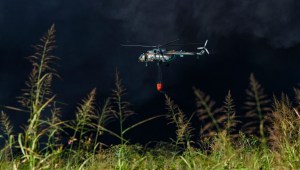 Un helicóptero de bomberos transporta agua el 9 de agosto de 2022 para combatir el enorme incendio en un depósito de combustible provocado por un rayo en Matanzas, Cuba.