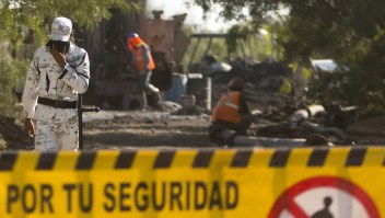 Un miembro de la Guardia Nacional (a la izquierda) vigila la entrada de la mina de carbón inundada donde 10 mineros quedaron atrapados tras un derrumbe, en la comunidad de Agujita, municipio de Sabinas, estado de Coahuila, México.