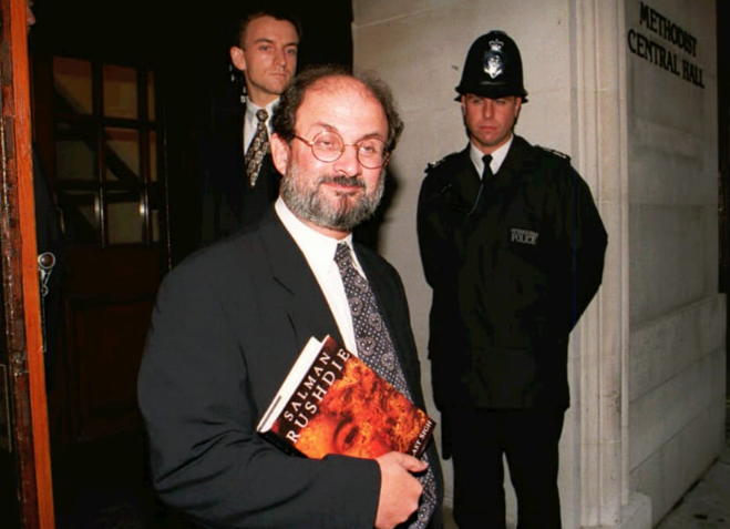 Rushdie llega al Central Hall de Londres el jueves 7 de septiembre de 1995 para participar en un foro público titulado "Escritores contra el Estado". Rushdie sostiene bajo el brazo un ejemplar de "El último suspiro del moro", su primera gran novela desde "Los versos satánicos". (Crédito: Rebecca Naden/AP)