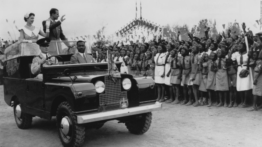 Kraljica Elizabeta II. in princ Philip mahata množici študentov na mitingu na dirkališču v Ibadanu v Nigeriji 15. februarja 1956.