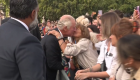 Mujer besa al rey Carlos III afuera del Palacio de Buckingham