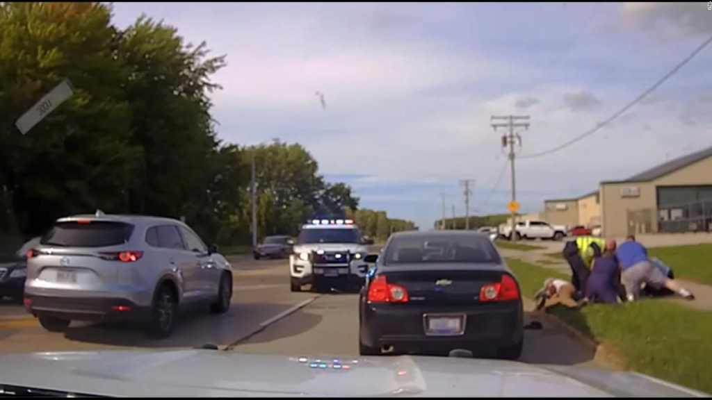 A police officer is assaulted and a motorist brakes to help her