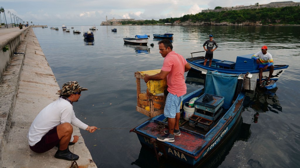 Pescadores se preparan para sacar sus barcos de un canal en La Habana, Cuba, este lunes ante la llegada del huracán Ian. (Foto: Alexandre Meneghini/Reuters)