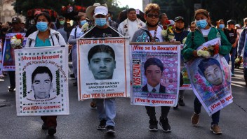 Manifestantes sostienen pancartas durante una protesta para conmemorar el octavo aniversario de la desaparición de los 43 estudiantes de Ayotzinapa, el 26 de septiembre de 2022 en la Ciudad de México, México.