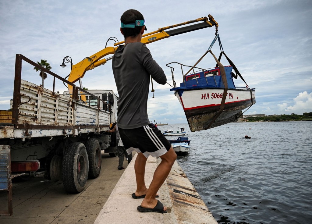 Un hombre ayuda a sacar pequeñas embarcaciones de la bahía de La Habana, el 26 de septiembre de 2022, en momentos en que se espera el impacto del huracán Ian en Cuba.