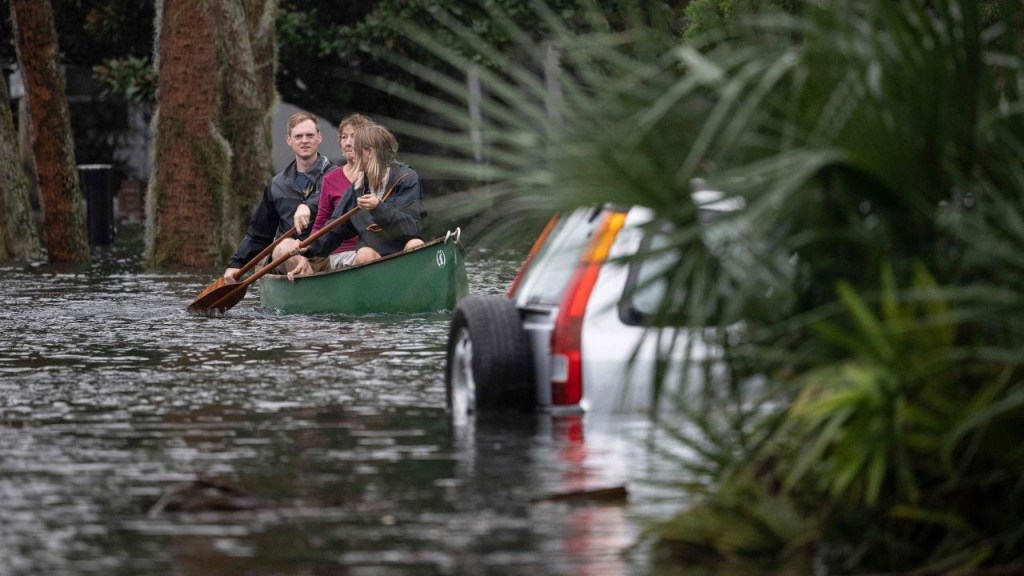 Unas personas pasan remando en una canoa junto a un auto sumergido tras el paso del huracán Ian por Orlando, el 29 de septiembre de 2022.