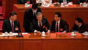 El ex líder de China Hu Jintao es levantado de su silla por un joven ayudante en la clausura del Congreso del Partido Comunista el sábado.