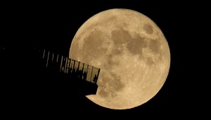 Personas en la plataforma de observación Edge NYC en la ciudad de Nueva York mientras sale la luna llena el 20 de octubre de 2021.