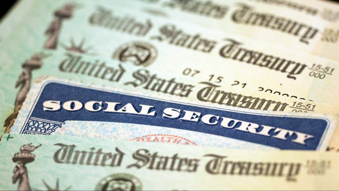 Una tarjeta del Seguro Social se encuentra junto a cheques del Departamento del Tesoro de Estados Unidos.