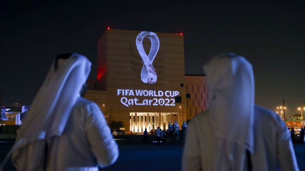 Qataríes se reúnen en el tradicional mercado Souq Waqif de Doha mientras se proyecta el logo oficial del Mundial 2022 en un edificio en septiembre de 2019. (Foto: -/AFP/AFP vía Getty Images)